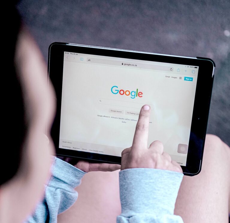 Woman holding a tablet with Google search on the screen.