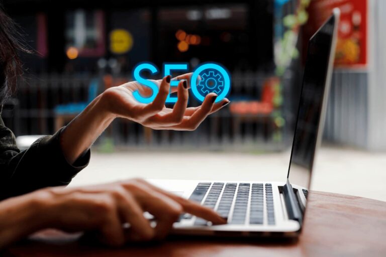 A woman looking at a laptop with the word “SEO” in her hand.